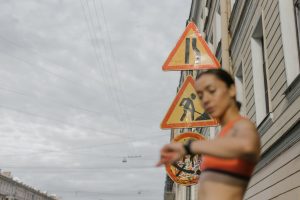 a woman in orange sports bra standing near the road signs